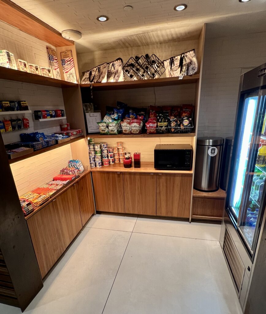 a room with shelves of snacks and a refrigerator