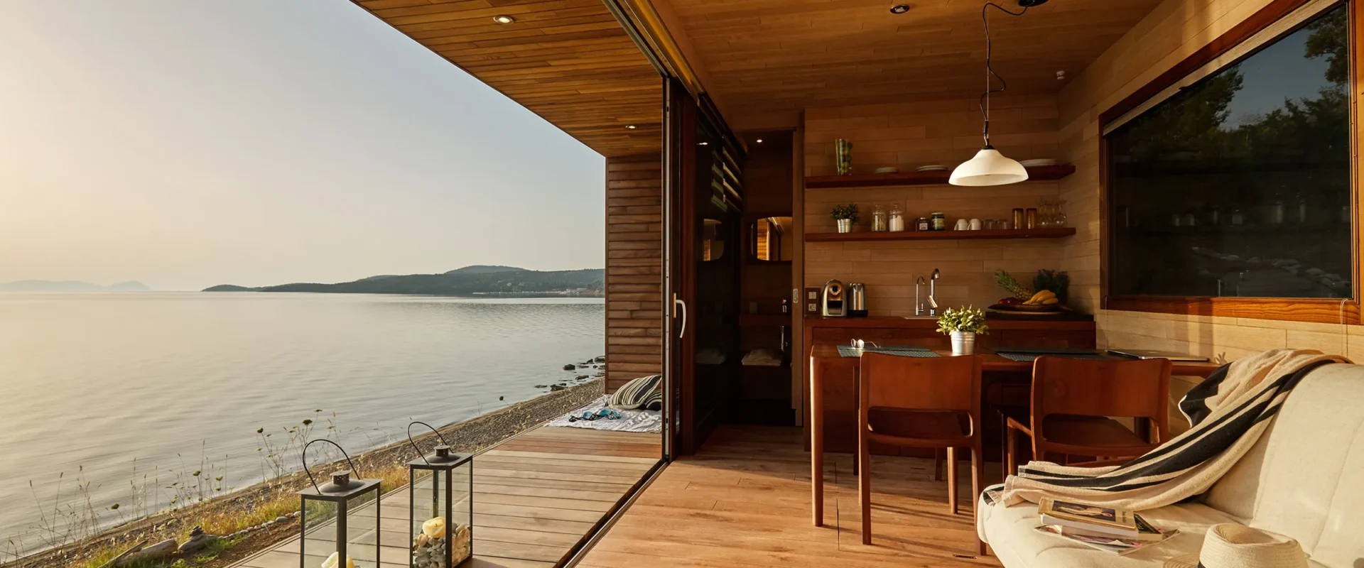 a room with a table and chairs and a large window overlooking a body of water