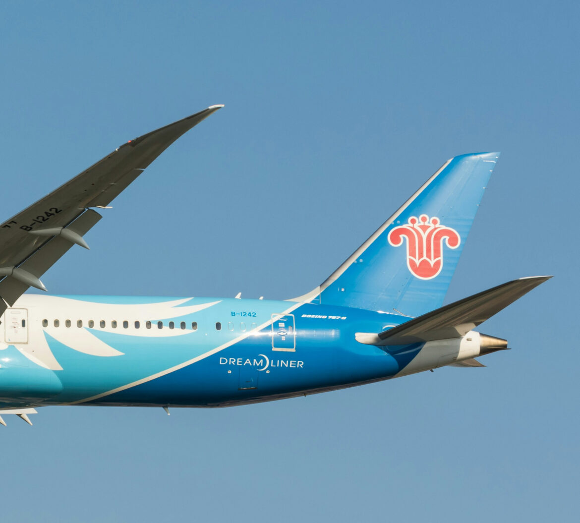 a blue and white airplane in the sky