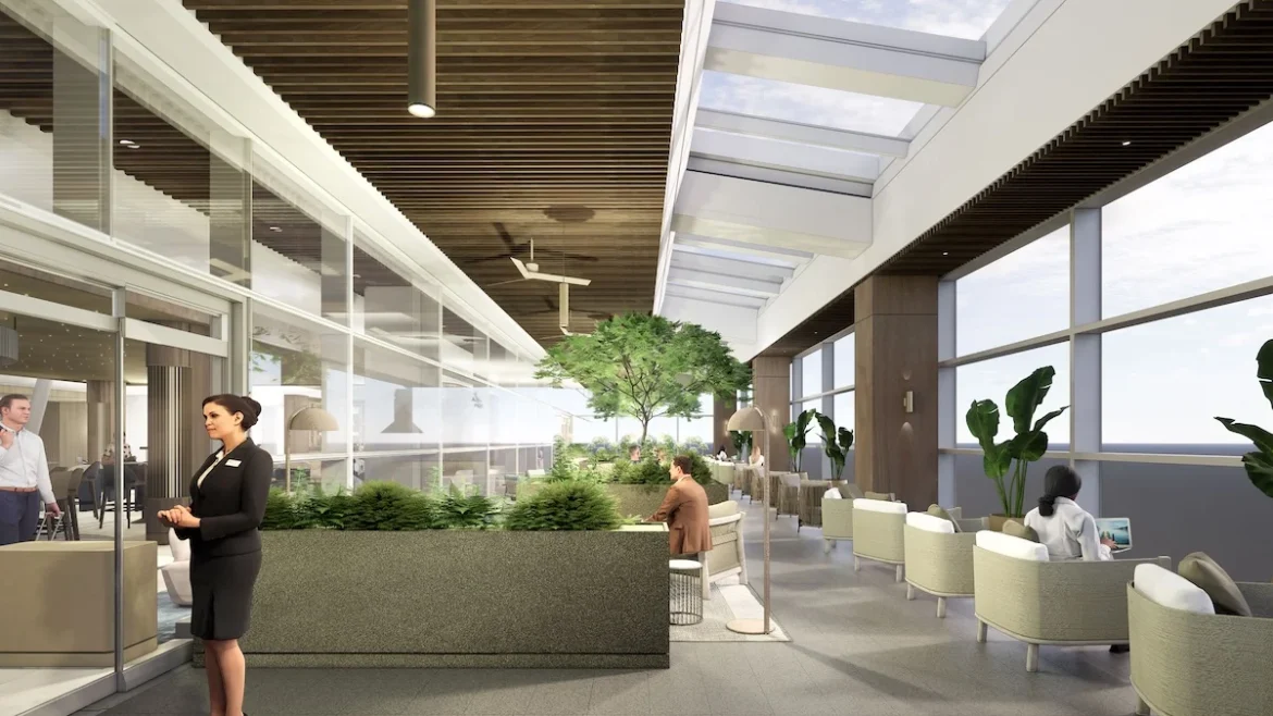 a man sitting at a desk in a room with plants