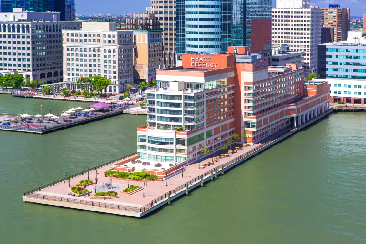 Hyatt Regency JC Exterior a large building next to a body of water
