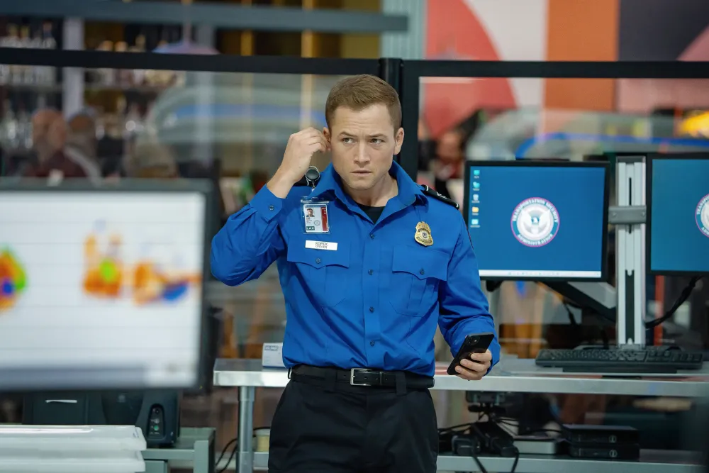 a man in a blue shirt holding a phone