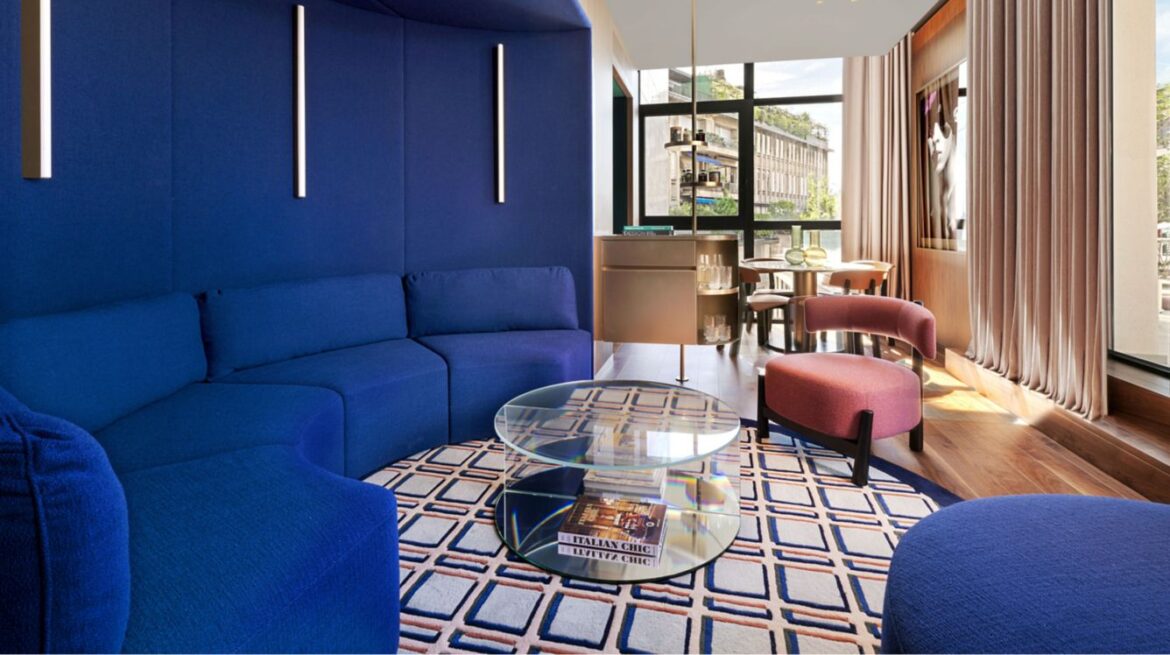 a room with blue couches and a glass coffee table