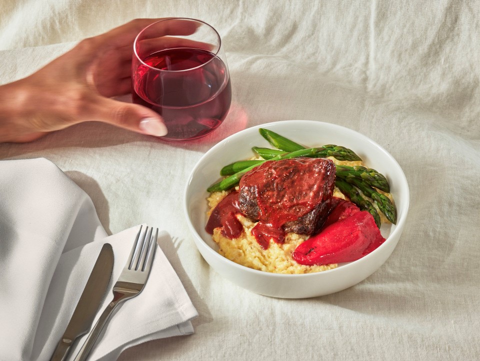 a bowl of food and a glass of wine
