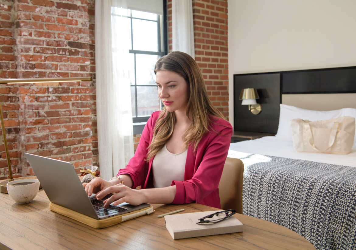 a woman sitting at a desk using a laptop